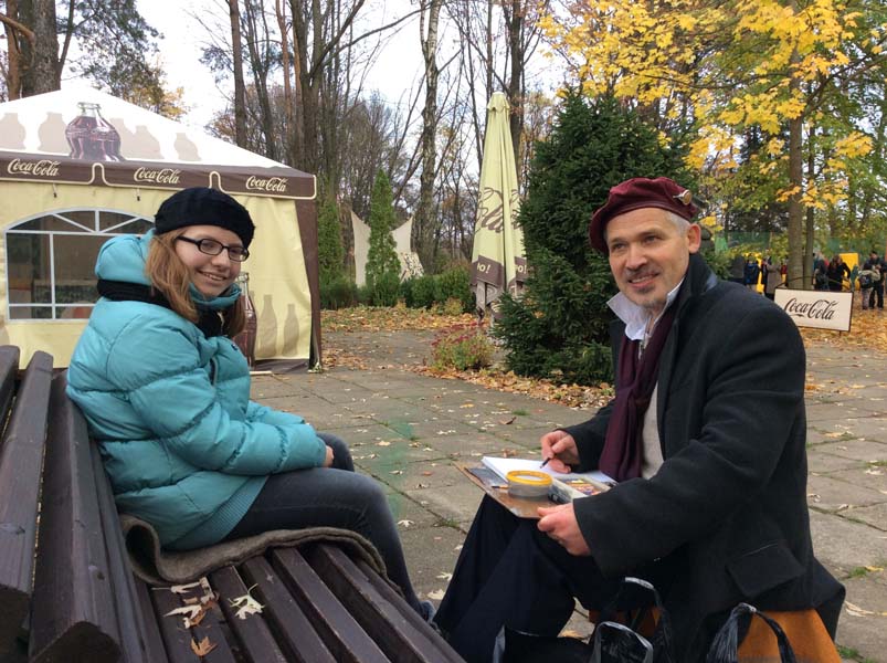 шаржист Мишель рисует шаржи в ботаническом саду Настю