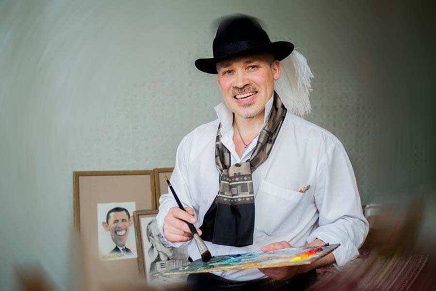 шаржист в шляпе со страусиным пером на ссвадьбе в мастерской